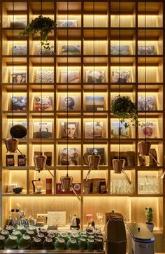 a coffee shop with shelves filled with cups and other items on the wall behind them