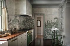 the kitchen is decorated in green and white with palm leaves on the backsplash