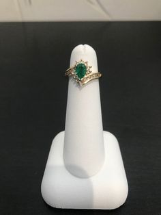 This beautiful dark green pear-shaped emerald is surrounded by round brilliant diamonds set in prongs.  There are channel set round diamonds set down both sides of the ring.  This stunner is priced to sell!  This ring is a size 3 3/4, but can be sized for an additional charge. Teardrop Emerald Ring With Diamond Prong Setting, Green Diamond Emerald Ring, Pear-shaped, Green Emerald Diamond Ring, Pear-shaped, Green Emerald Diamond Ring Pear-shaped, Green Diamond Emerald Ring Pear-shaped, Pear-shaped Green Emerald Diamond Ring, Formal Green Pear-shaped Diamond Ring, Green Pear-shaped Emerald Diamond Ring, Green Teardrop Diamond Ring For Formal Occasions