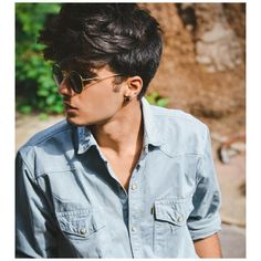 a young man wearing sunglasses looking off to the side