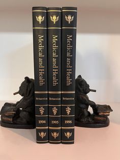 three black books with gold lettering on them