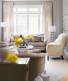 a living room filled with furniture and yellow flowers