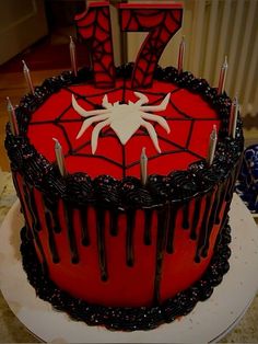 a red and black cake with spiderman decorations