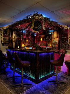 the bar is decorated with neon lights and tropical decorations, along with leather stools