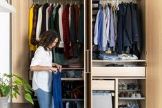 a woman standing in front of a closet filled with clothes