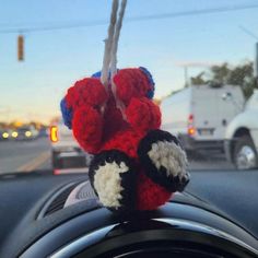 a stuffed animal hanging from the dashboard of a car