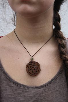 This beautiful and unique hand-carved Celtic pendant will be made for you, or a loved one, in my studio on the West of Ireland. This intricate Celtic knot pendant features a piece of walnut, recycled from musical instruments constructed by a local luthier. As a musician myself, I take enormous satisfaction in creating a necklace whose inherent wood has previously featured in a beautiful hand-made guitar. Also, part of walnut's attractiveness is its durability and ability to stand the test of tim Rustic Adjustable Etched Jewelry, Brown Etched Jewelry As Gift, Brown Etched Jewelry As A Gift, Rustic Brown Engraved Jewelry, Rustic Carved Jewelry As Gift, Brown Engraved Round Pendant Jewelry, Carved Brown Jewelry For Gifts, Artisan Hand-tooled Necklace For Gift, Adjustable Carved Nature-inspired Jewelry