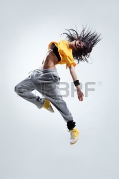 a man in the air with his hair flying through the air while wearing sweatpants and sneakers