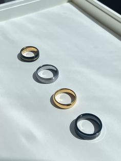 three different colored rings sitting on top of a white surface