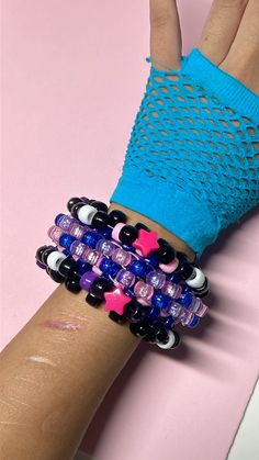 a woman's arm with several bracelets on it and a pink star in the middle