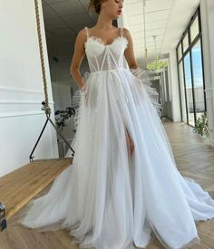 a woman in a white dress standing on a wooden floor