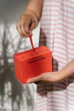 a person holding an orange box in their hand