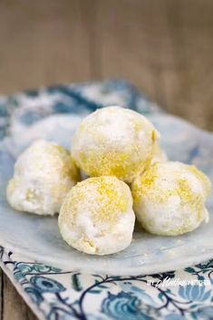 some powdered donuts are on a blue and white plate