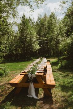 a long wooden table is set up in the grass