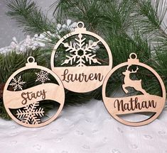 three wooden ornaments with snowflakes and names hanging from the top of each ornament