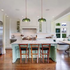 a kitchen with an island and stools in it