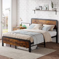 a bed sitting in a bedroom next to a white brick wall and wooden flooring