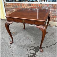 an antique desk with glass top in front of a brick wall