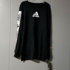 Size Med 10/12 Sporty Black T-shirt For Fall, Black Adidas Tops For Sports, Black Sports T-shirt For Spring, Adidas Long Sleeve Sports T-shirt, Black Long Sleeve Top With Logo, Adidas Long Sleeve Cotton T-shirt, Adidas Fall Streetwear Top, Adidas Long Sleeve Top With Logo Print, Adidas Tops With Graphic Print For Fall