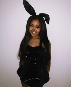 a woman with bunny ears on her head and black latex outfit posing for the camera