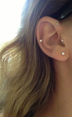 a close up of a person's ear with two piercings on it,