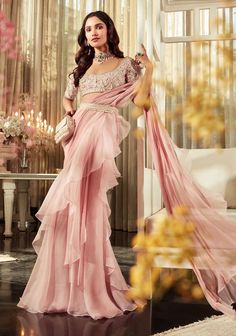 Editor's Note This elegant ensemble includes an embroidered net blouse with intricate detailing paired with a flowing organza chiffon draped saree. The look is completed with a beautifully embr... Saree Chiffon, Onion Pink, Ridhi Mehra, Net Blouse, Draped Saree, Fancy Sarees Party Wear, Modern Saree, Ruffle Saree, Embroidered Crop Tops