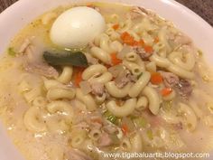 a bowl of soup with noodles, meat and an egg on the top is ready to be eaten