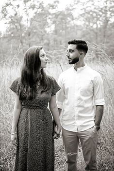 a man and woman standing in tall grass