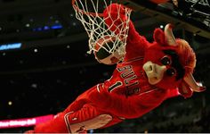 a mascot is dunking the basketball through the net