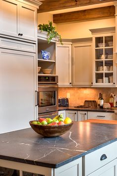 a bowl of fruit is sitting on the kitchen counter