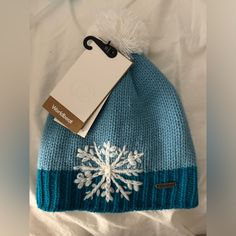 a blue hat with a white snowflake on it and a tag attached to it