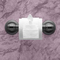 a roll of toilet paper sitting on top of a black wall mounted tissue dispenser