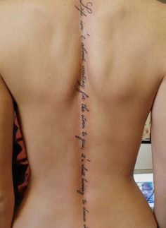 the back of a woman's upper body with writing on her left shoulder and lower back