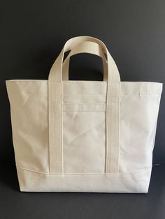 "Canvas tote bag, classic in styling. Heavy 18 oz cotton duck will serve you well as a stylish canvas tote for just about anything! Use it as a shopping bag, a beach bag, overnight bag. The bag has double bottom, sturdy 1.5\" wide handles, with webbing that is sewn around the bottom of the bag. Key hook, exterior slip pocket. Choose from 8 colors. Dark Olive and Natural are shown in photos. Dimensions: 22\" wide across top 14\" high 6\" deep 16\" x 6\" bottom Handles are 6\" drop, 14\" long Exte Cheap Bucket Tote Bag With Handles, Cheap Chic Canvas Bucket Bag, Cheap Canvas Bucket Bag With Multiple Compartments, Cheap Cotton Bucket Bag Tote, Cheap Canvas Shoulder Bag With Canvas Lining, Cheap Trendy Canvas Bag With Adjustable Handle, Cheap Trendy Tote Bucket Bag, Cheap Solid Canvas Bag With Adjustable Strap, Cheap Tote Canvas Bag For Beach