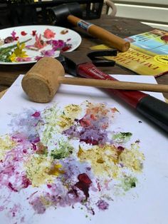 an art project with paint and brushes sitting on a table next to other arts and crafts supplies