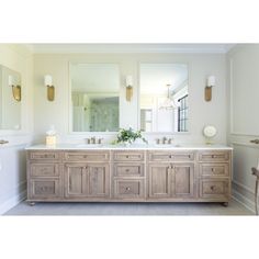 a large bathroom with two sinks and mirrors