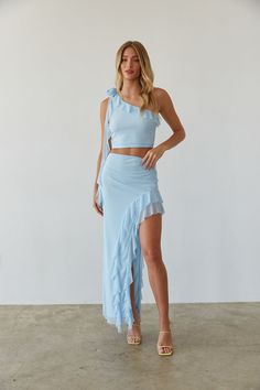 Stay vacation-ready in the Carissa Asymmetrical Ruffle Rosette Top! This one-shoulder crop top features a rosette embellishment on the right shoulder, ruffle neckline, and cascading ruffle drape. Pair this unique summer top with the Carissa Asymmetrical Ruffle Maxi Skirt for the perfect Summer vacation outfit! Details: Self: 90% Polyester, 10% Spandex Lining: 100% Polyester Lots of stretch Fully Lined Hand wash cold/ Lay flat to dry Cheap Blue Top With Asymmetrical Hem, Cheap Light Blue Tops With Ruffles, Luxury Blue Sets With Ruffles, Rosette Top, Asymmetrical Maxi Skirt, Blue Ruffle Top, Maxi Skirt Set, Ruffle Maxi Skirt, Light Blue Top