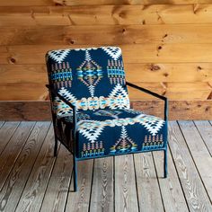 a chair sitting on top of a wooden floor next to a wood paneled wall