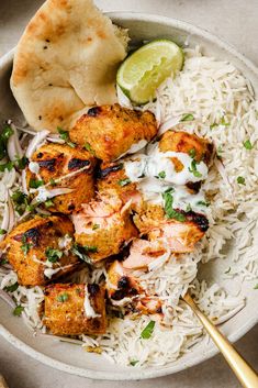 a white bowl filled with rice and chicken skewers