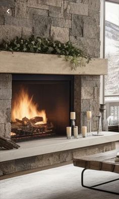 a living room with a fire place in the center and candles on the mantle next to it