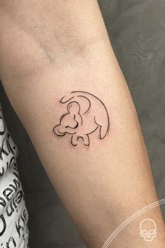 a small elephant tattoo on the left forearm and arm, with an outline of a baby elephant