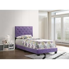 a bed with purple upholstered headboard and foot board in front of a window