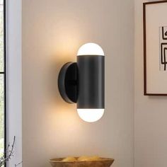 a wall mounted light in the corner of a room next to a bowl of fruit