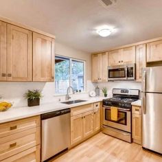 a kitchen with wooden cabinets and stainless steel appliances