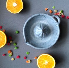 oranges and candy are scattered around a blue bowl with sugar cubes on it