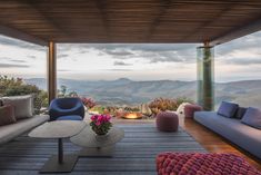 a living room filled with lots of furniture and a large window overlooking the mountain range