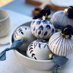 blue and white ornaments in a bowl on a table