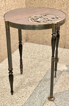 a small wooden table sitting on top of a tiled floor