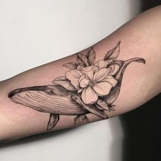 a whale with flowers on it's arm