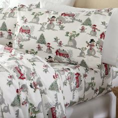 a bed covered in white and red christmas themed sheets